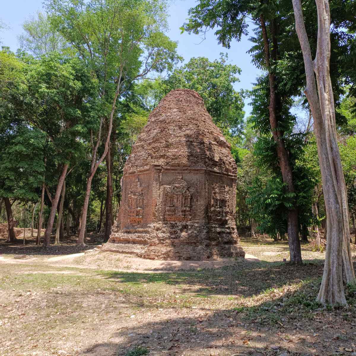 Ancient brick temple ruins at Sambor Prei Kuk surrounded by tall forest trees during the Phnom Penh to Siem Reap private 5 days 4 nights Cambodia tour with sightseeing stops on the road.