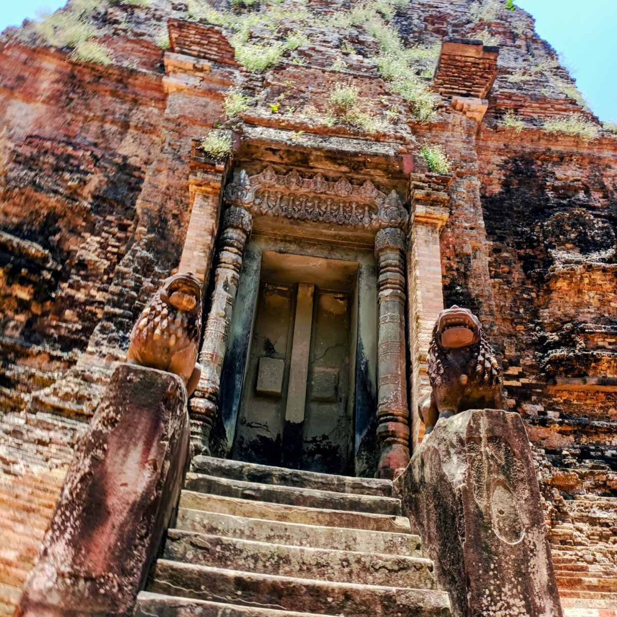 Close-up view of the temple entrance and stone lions at Sambor Prei Kuk, highlighting the historic temple stop included in the Phnom Penh to Siem Reap itinerary.
